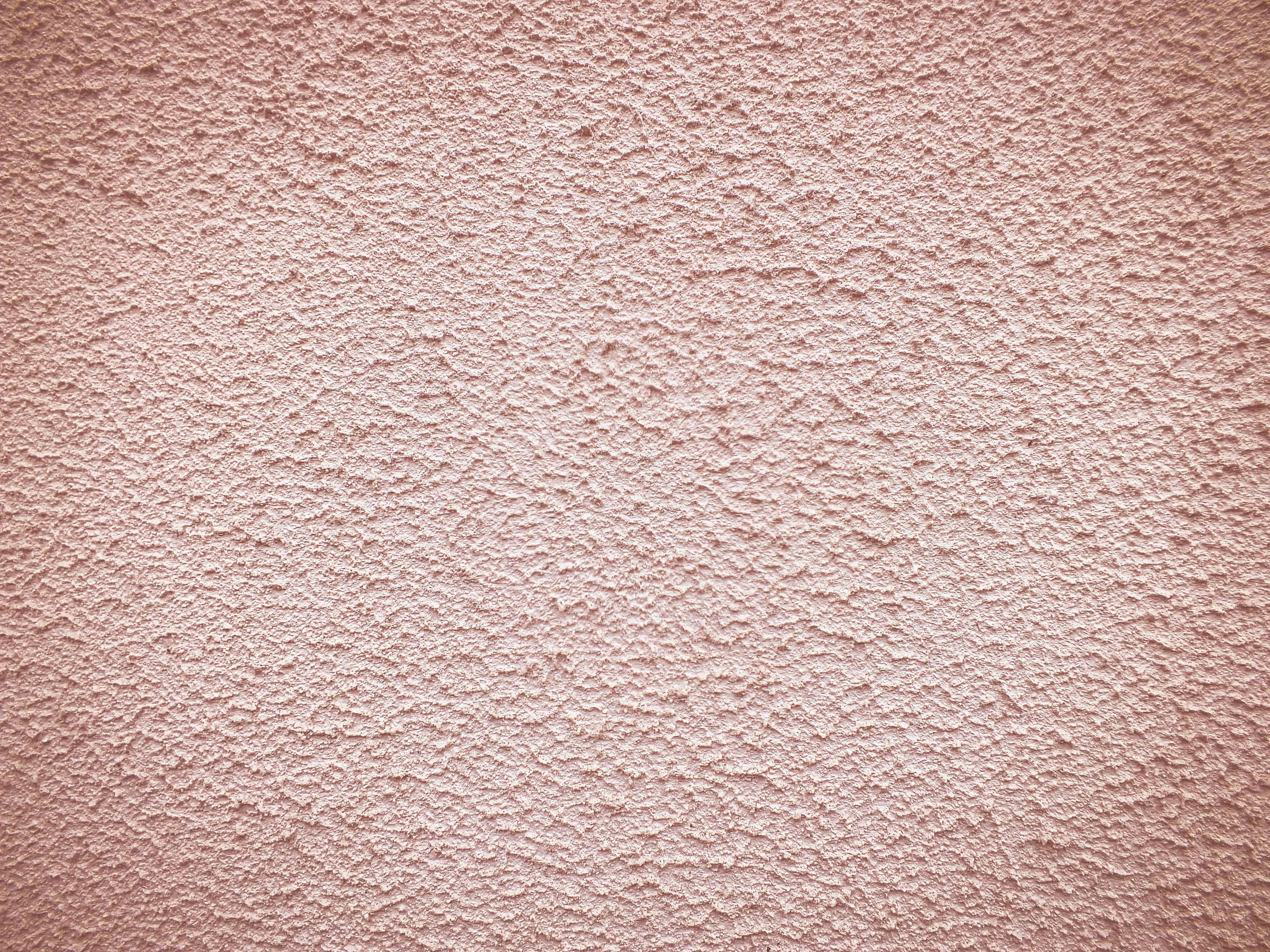 a close up of a pink stucco wall